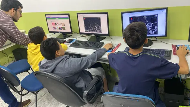 Jovens programando no Scratch com apoio de um monitor